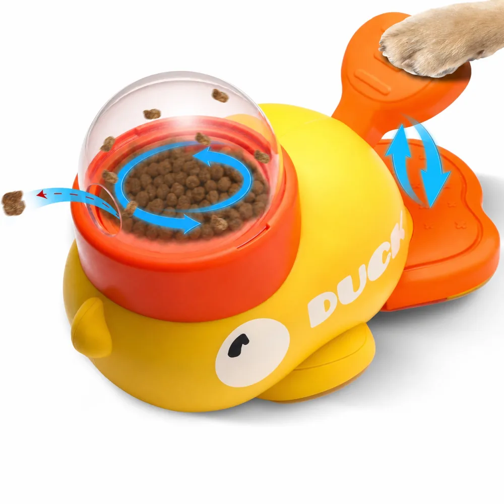 Close-up of a yellow duck treat dispenser with a dog paw pressing the orange lever